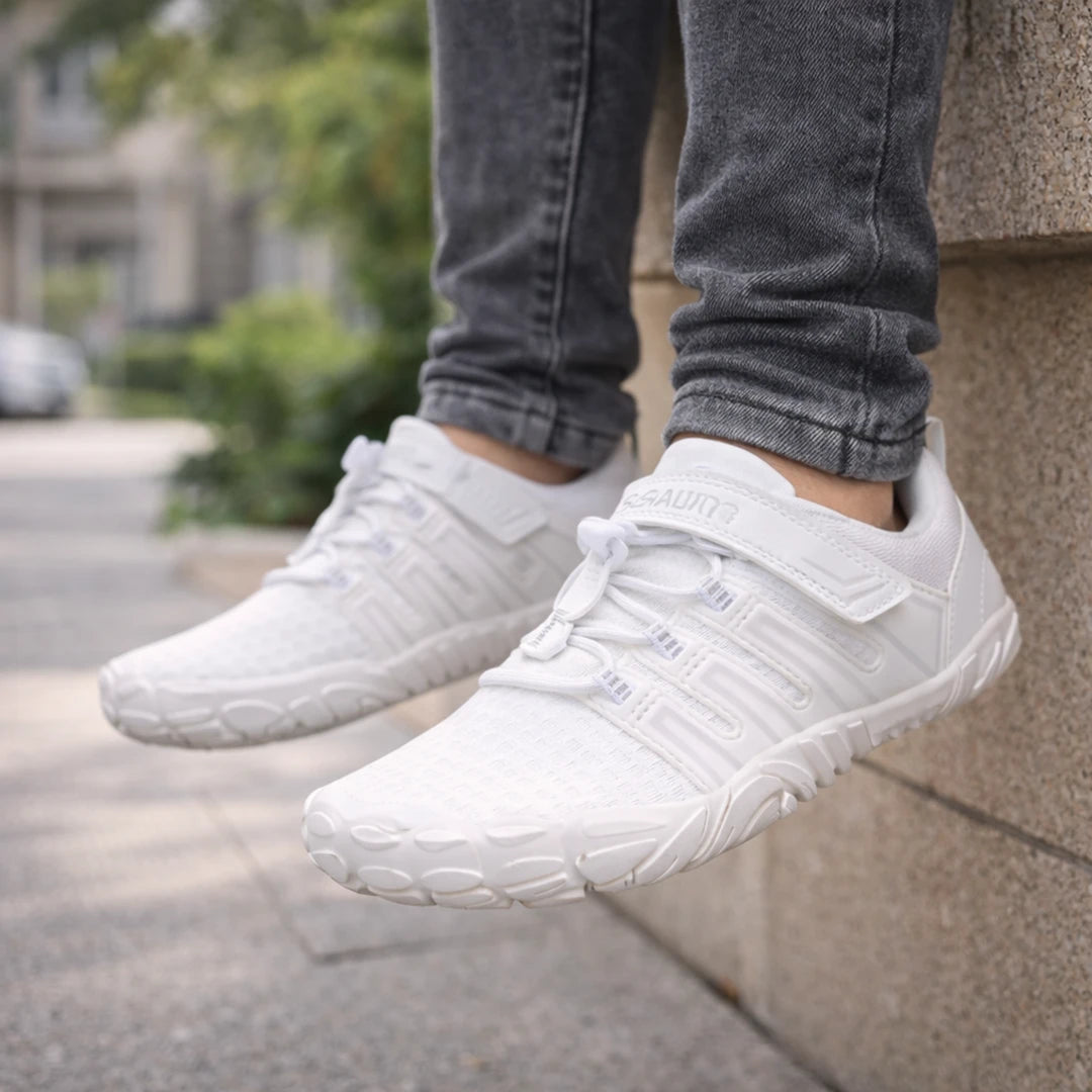 Detalle de bebe zapatillas blancas ergonómicas en uso real para paseos y juegos.