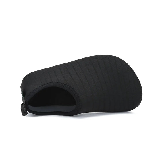 Tejido tipo calcetín de neopreno en zapatilla de agua negra.