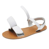 Detalle del doble cierre de velcro abierto en sandalia barefoot plateada para fácil calce.
