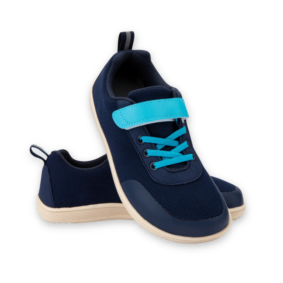 Par de bebe zapatillas azules con sistema de ajuste de velcro para fomentar la autonomía.