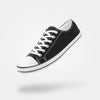 Zapatillas barefoot urbanas Saguaro Roam II en lona negra con suela flexible blanca.